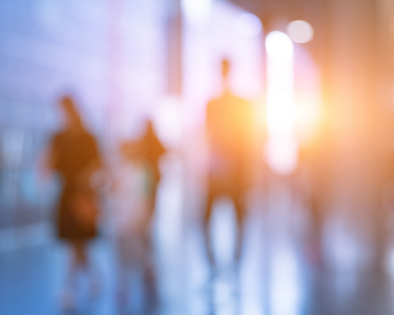 Silhouettes of people in a hurry to get to their jobs in the corridor of a modern building