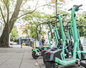 closeup image of electric scooters parked on sidewalk