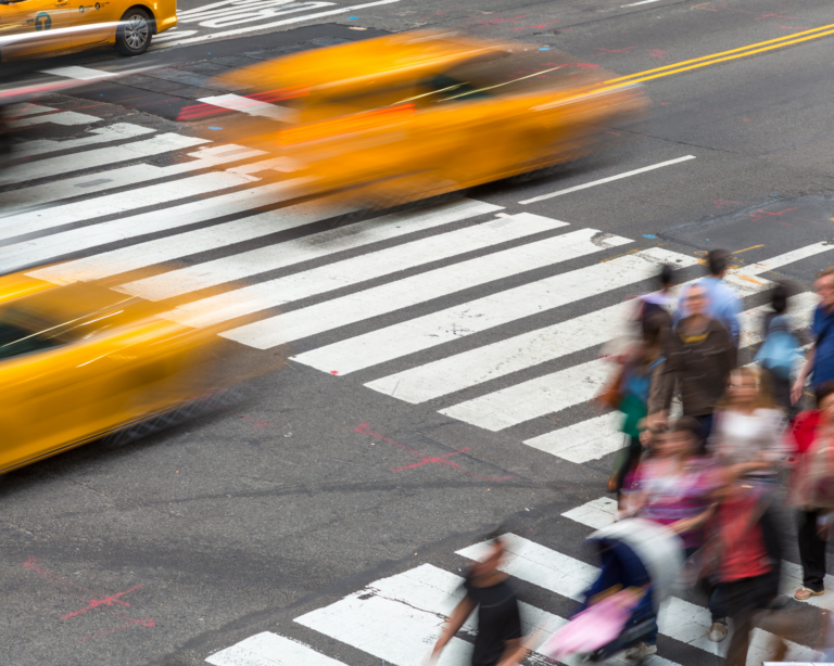 Pedestrians and yellow taxi cabs on a pedestrian crossing. City noise concept