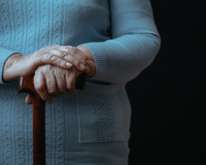 Older person with walking stick. Aging concept