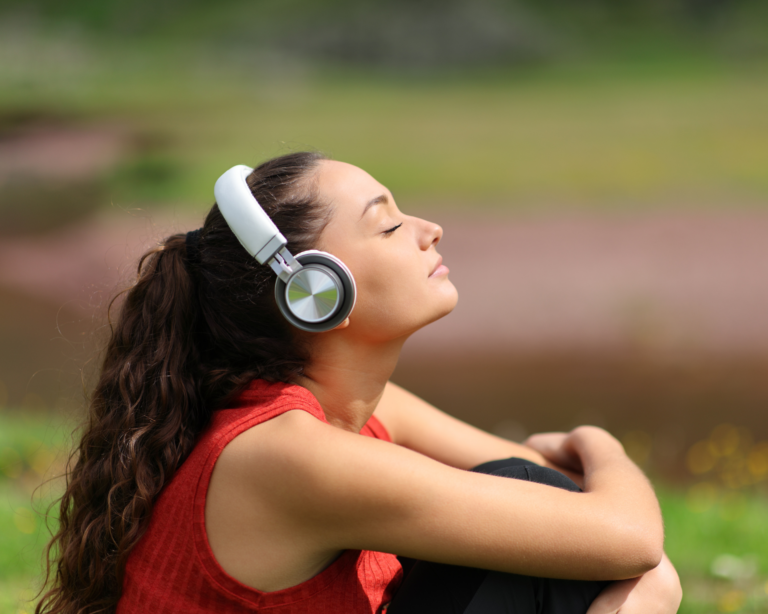 portrait of a young woman wearing headphones, listening to a guided meditation for her mental health