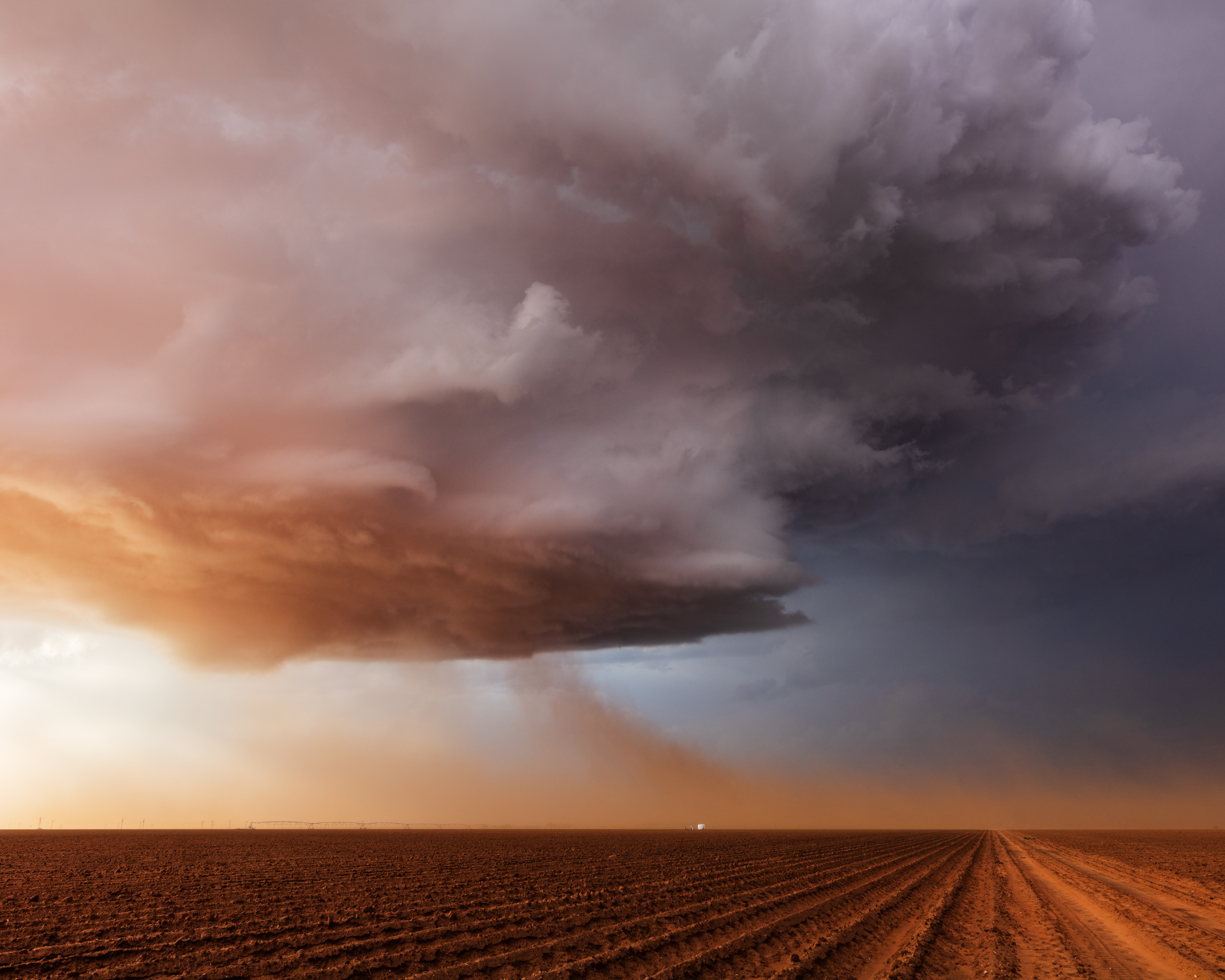Blowing dust feeds into a dramatic supercell thunderstorm at sunset near Levelland, Texas