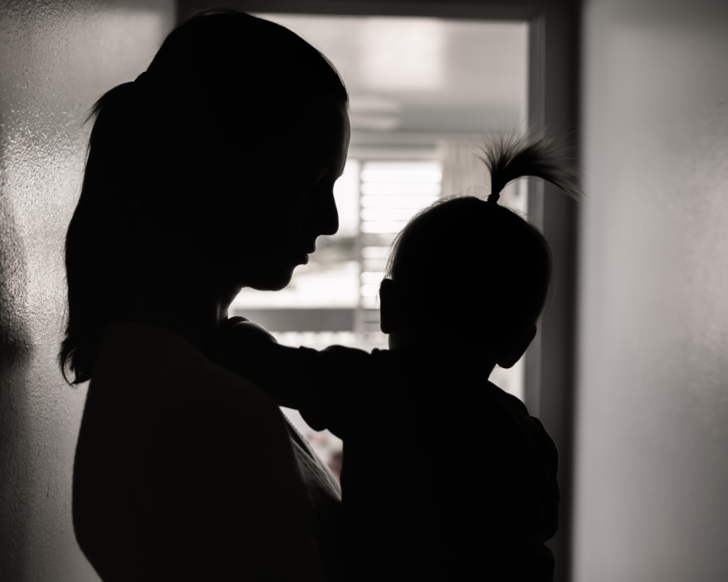 silhouette of a stressed mother taking care of her young child