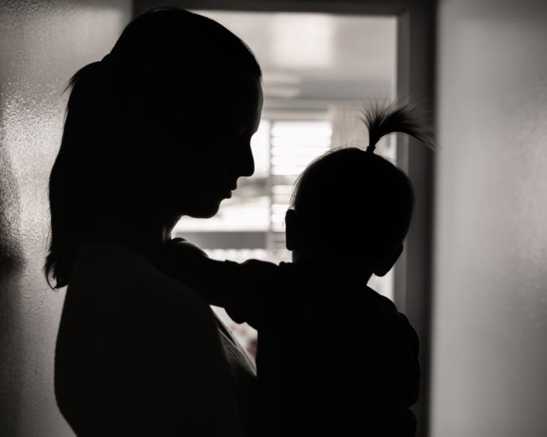 silhouette of a stressed mother taking care of her young child