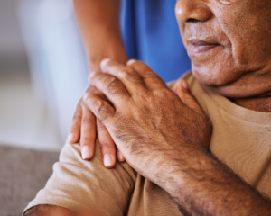 Support, care and helping hands for an elderly patient during a consultation at a nursing clinic. Closeup of hope, trust and comfort from a woman caregiver consulting a senior man in retirement home