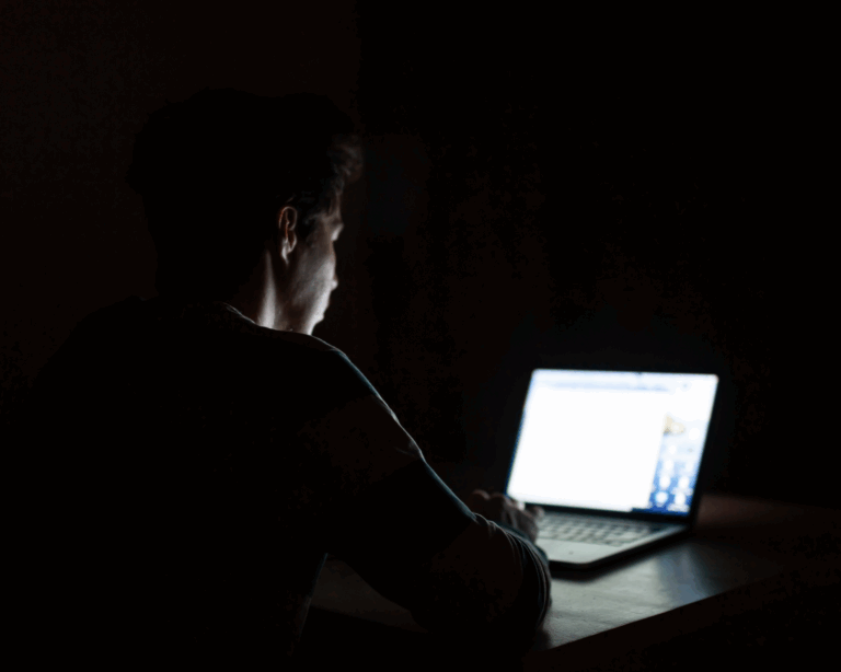 young man on computer in dark room. manosphere concept