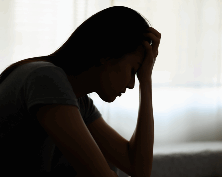 Silhouette photo of a young woman feeling discomfort and pain