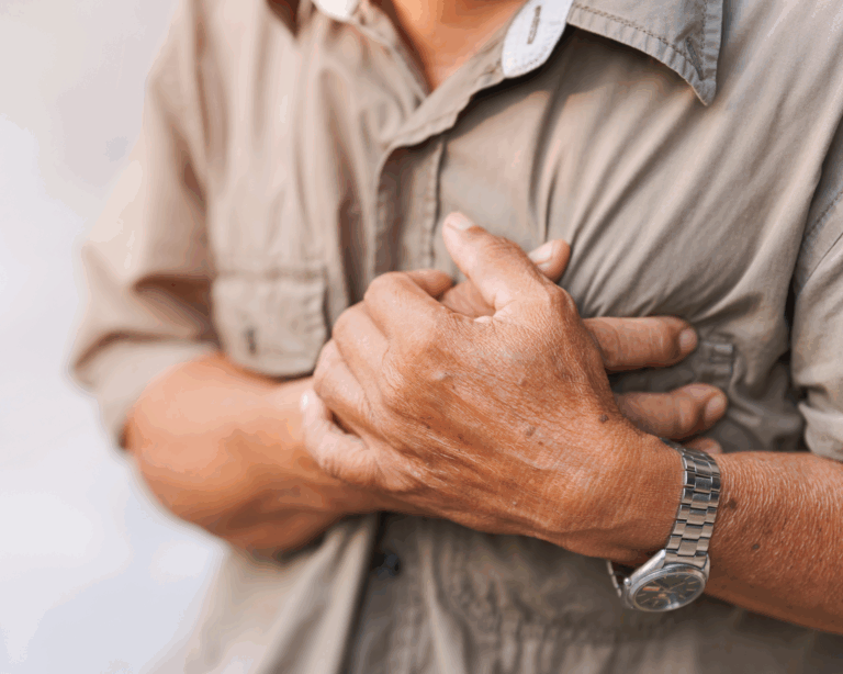 Close-up of an elderly man's hand holding his chest in pain. Heart attack concept