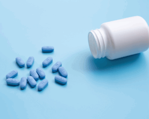 spilled bottle of PrEP pills on blue background