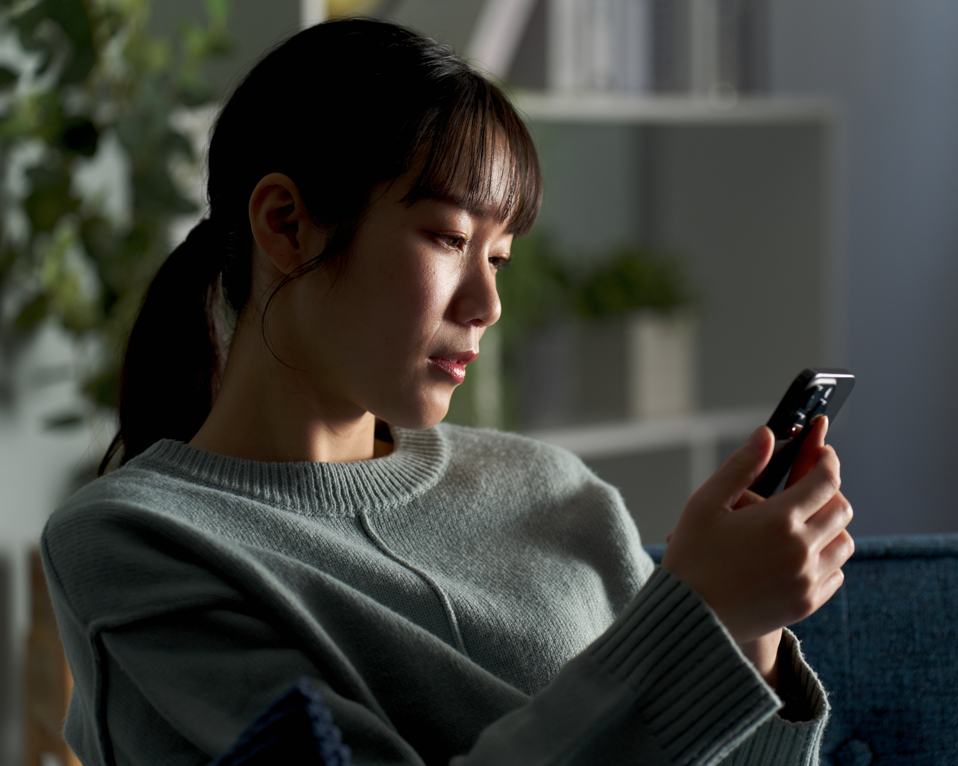 Portrait of a young woman scrolling on her phone with a concerned look on her face. Concept for finding health information on social media