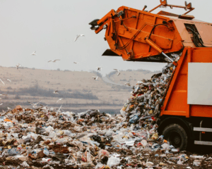 Garbage truck dumping the garbage in a landfill. Pollution and superfund site concept