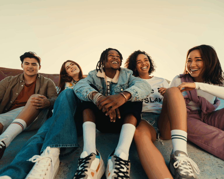 Group of friends enjoying time together outdoors, smiling and laughing. Social connection concept