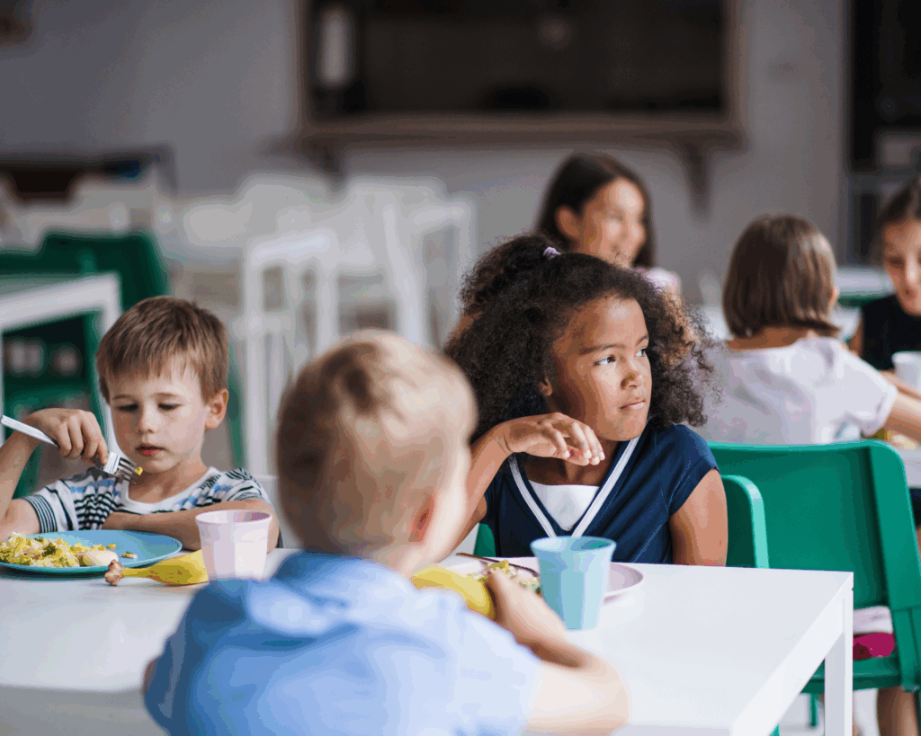 Group of young kids eating lunch in school cafeteria
