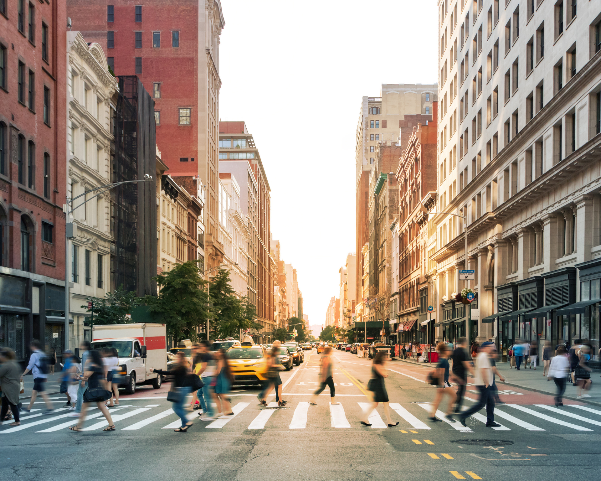 Crowds of blurry people walking through a busy crosswalk