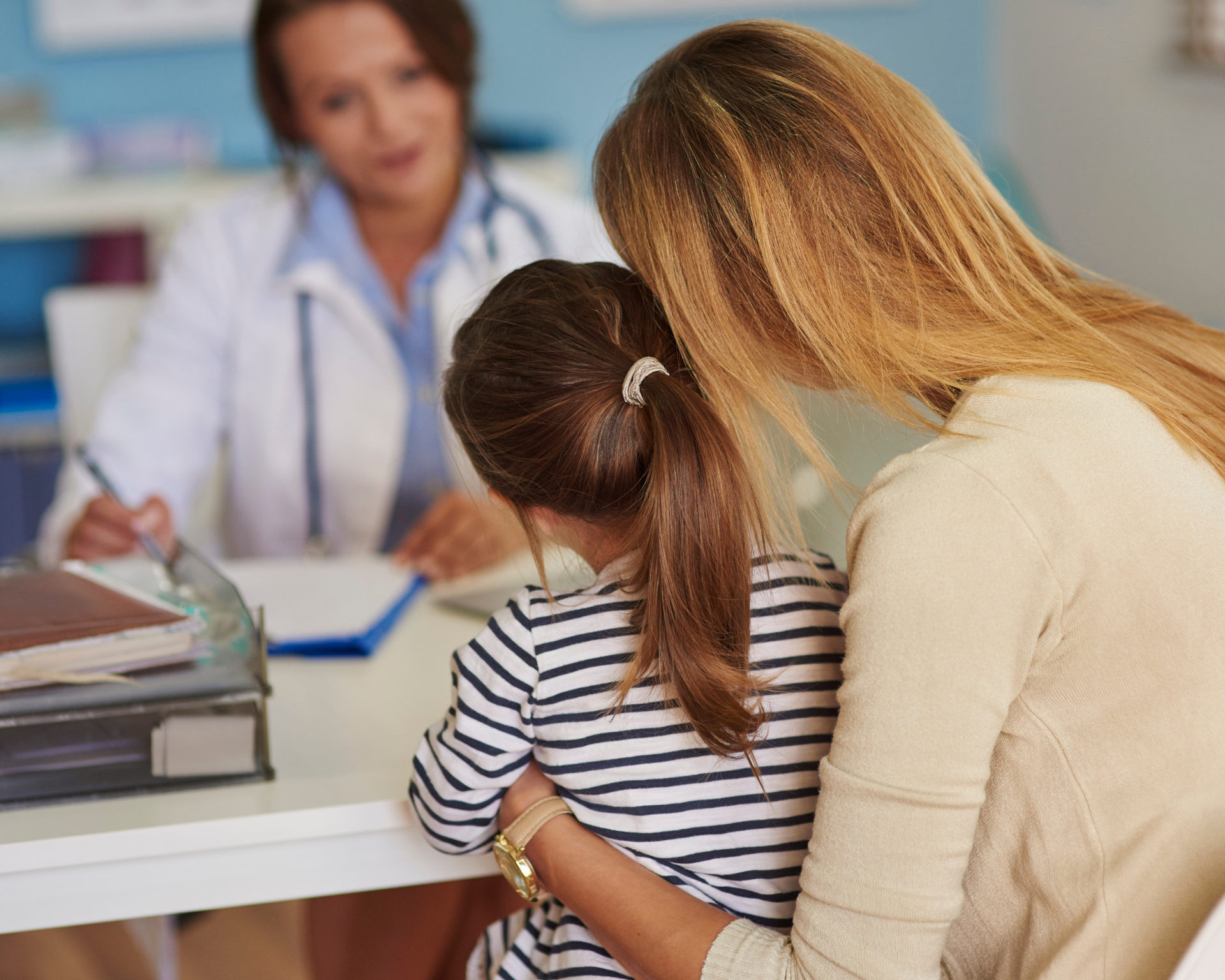 Portrait of a young girl and her mom speaking with a doctor. Diagnosis concept