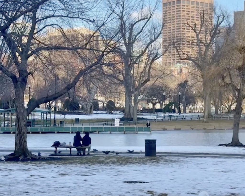 Photo of a couple sitting on a snowy bench a park. Community concept.