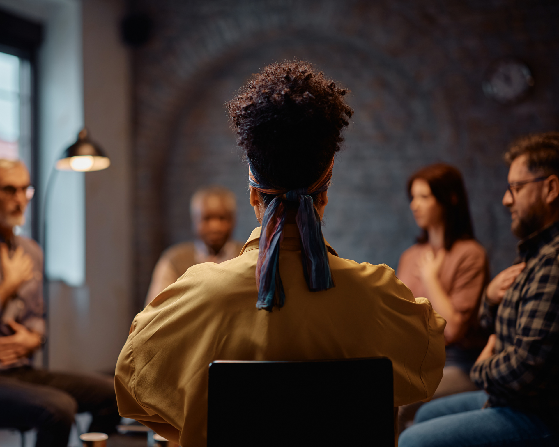 Rear view of a woman during group therapy at a health center