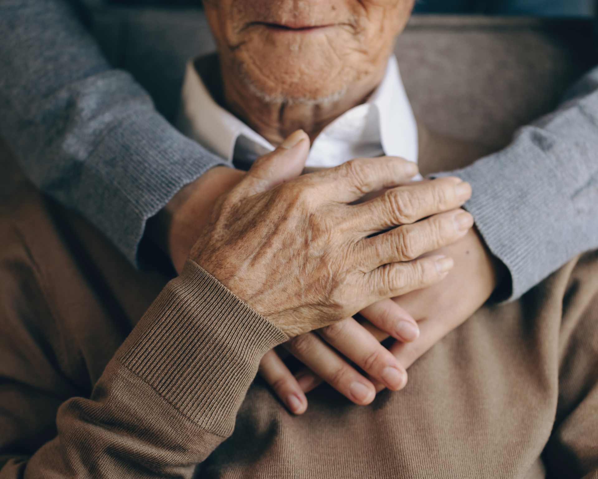 Portrait of a patient holding the caregiver's hand while spending time together. Elderly health care concept