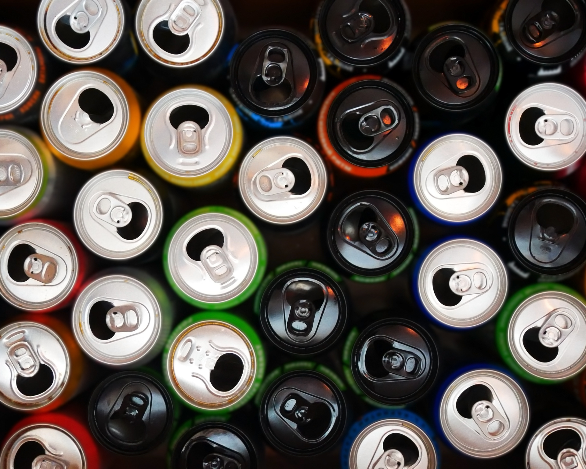 A colorful background of many opened and drunk cans of different energy drinks