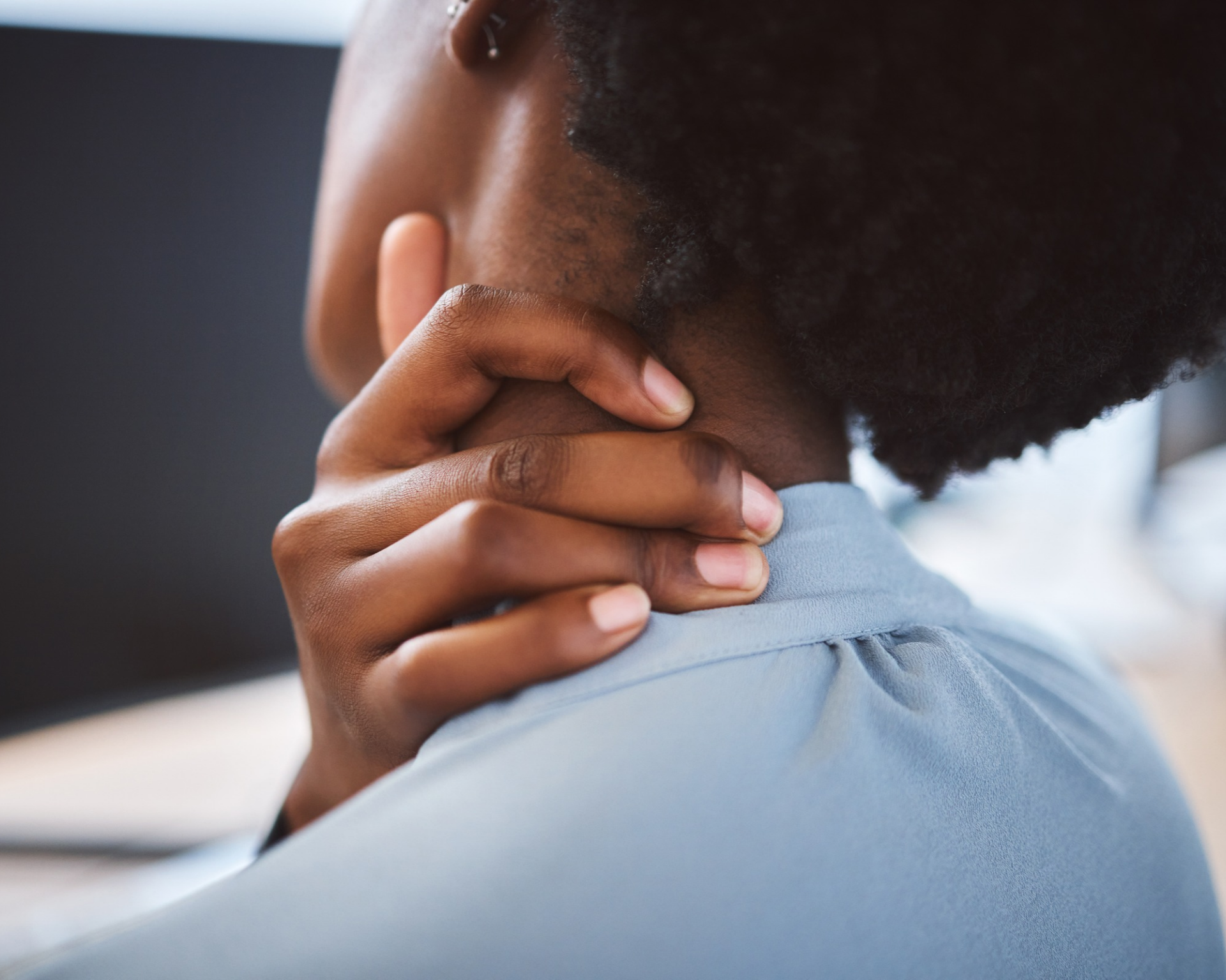 Close-up of a young woman rubbing neck due to pain. Concept of management for feeling tense, strained, uncomfortable, and hurt