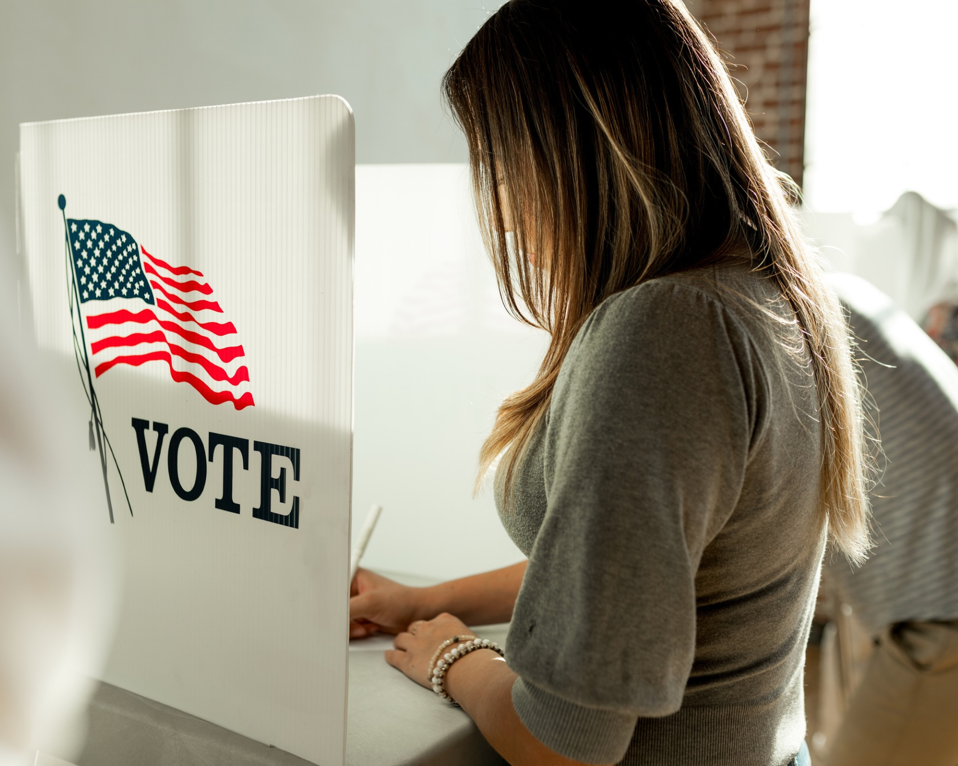 Portrait of a young woman filling out her ballot on election day. Voter and voting concept