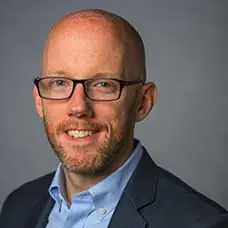 a man wearing glasses and a suit