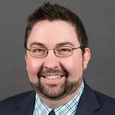 a man wearing glasses and a suit