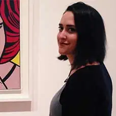 a woman standing in front of a painting