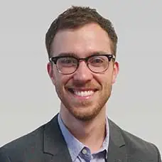 a man wearing glasses and a suit