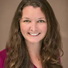 a woman with long brown hair smiling