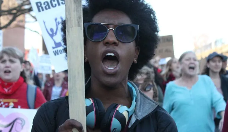 a person holding a sign and holding a stick