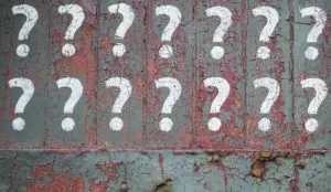 Question marks painted on a rusty peeling wall