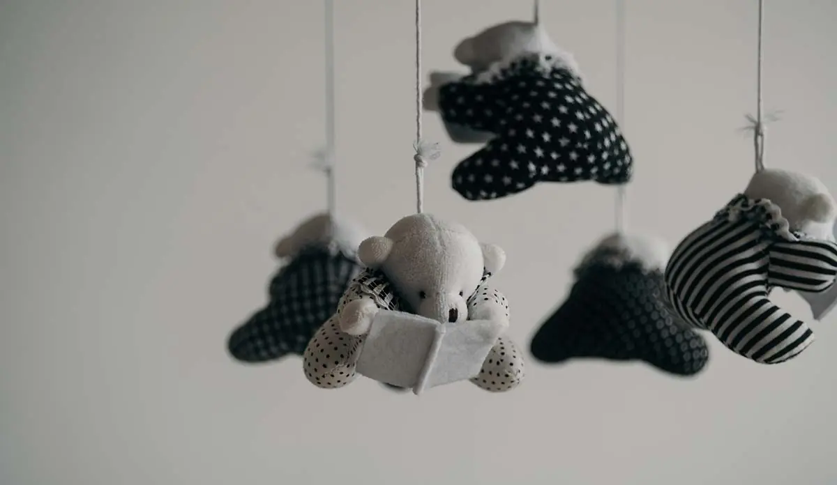 a mobile with teddy bears and a book