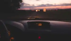 Looking out the windshield of a car at the highway at dusk