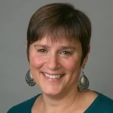 a woman with short hair wearing earrings