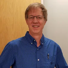 a man wearing glasses and a blue shirt