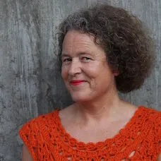 a woman with curly hair wearing an orange shirt