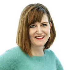 a woman with red hair wearing a blue sweater