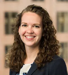 a woman with curly hair smiling