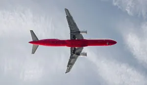 a red and white airplane in the sky