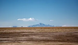 a large flat ground with a mountain in the background