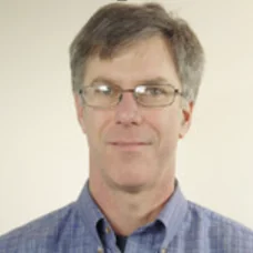 a man wearing glasses and a blue shirt