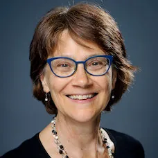 a woman wearing blue glasses and a necklace