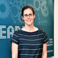 a woman standing in front of a blue sign