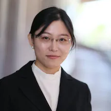 a woman wearing glasses and a black jacket