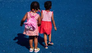 two girls walking on a blue surface