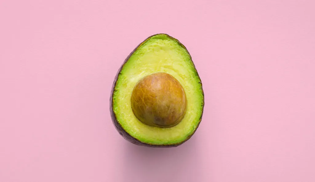a half of an avocado with a seed in it