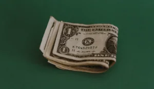 a stack of money on a green surface