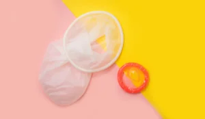 a condom and a condom on a yellow and pink background