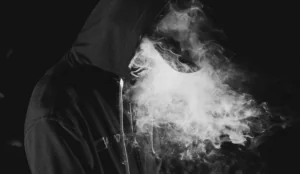 a person wearing a hoodie with smoke coming out of their face